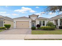 Charming single-story home with a paver driveway, tan garage door, and well-manicured landscaping at 7928 Hanson Bay Pl, Kissimmee, FL 34747