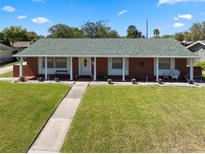Charming single-story home featuring a brick facade, white columns, and a well-manicured lawn, offering great curb appeal at 812 Arlington Blvd, Altamonte Springs, FL 32701