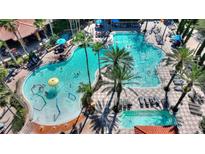Aerial view of a resort-style pool featuring palm trees, lounge chairs, and water features at 12544 Floridays Resort Dr # 102, Orlando, FL 32821