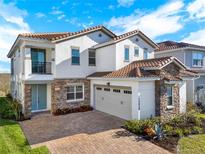Stunning two-story home boasting a tile roof, stone accents, a spacious two-car garage and a brick-paved driveway at 13628 Abberwick Dr, Orlando, FL 32832