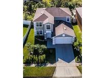 Charming two-story home featuring an attached two-car garage and well-maintained front lawn with mature trees at 1416 Aguacate Ct, Orlando, FL 32837