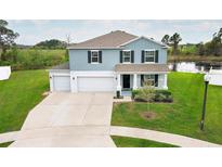 Charming two-story home with a three-car garage and a well-manicured front yard with pond view at 15216 Langsdale Ct, Mascotte, FL 34753