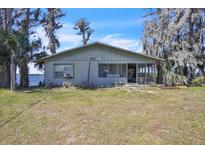 Charming lakefront home featuring a screened porch and surrounded by mature trees at 18951 Lake Pickett Rd, Orlando, FL 32820