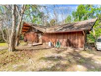 Rustic wooden home with unique architectural features blends seamlessly with its natural surroundings at 220 Wekiva Park Drive, Sanford, FL 32771