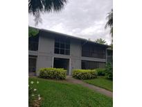 Two-story condo building featuring well-maintained landscaping and neutral color palette at 2548 Oak Park Way # 102, Orlando, FL 32822