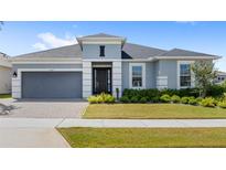 Charming single-story home featuring a well-manicured lawn, neutral paint, gray garage door, and a brick-paved driveway at 3347 Hanging Tide St, Winter Garden, FL 34787