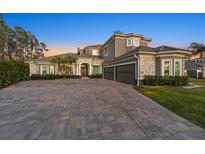 Elegant two-story home with stone accents, a three-car garage, and a large driveway at 4205 Clarice Ct, Windermere, FL 34786