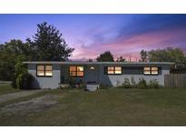 Charming single-story home with a well-maintained lawn and beautiful sunset sky at 5719 Meridian Way, Orlando, FL 32808