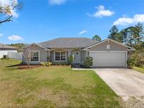 Charming single-story home with a well-manicured lawn and a two-car garage at 1139 9Th Ave, Deland, FL 32724