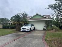 Charming one story home with a two car garage and an inviting driveway and front yard at 123 Breezy Oaks Ct, Davenport, FL 33896