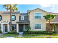 Two-story townhome showcases a landscaped front yard, mature palms, and neutral color palette at 12862 Strode Ln, Windermere, FL 34786