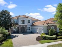 Beautiful two-story home featuring a brick driveway and tile roof, providing a luxurious curb appeal at 14172 Hutchinson St, Winter Garden, FL 34787