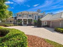 Stately two-story home featuring a circular driveway, manicured landscaping, and a tile roof at 1707 Stetson Ct, Longwood, FL 32779