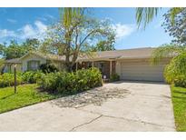 Charming single-story home featuring a lush front yard and a spacious driveway leading to an attached garage at 1873 Poinciana Rd, Winter Park, FL 32792