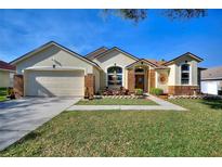 Charming single-story home with well-manicured lawn, landscaping, and inviting front fountain at 222 Via Mariel E Dr, Davenport, FL 33896
