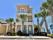 Charming three-story home with balconies and colorful exterior paint, surrounded by lush palm trees in a tropical setting at 3095 Key Lime Loop, Kissimmee, FL 34747