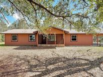 Charming single-story home featuring a metal roof and a cozy front porch with stone accents at 31926 Stearns Dr, Eustis, FL 32736