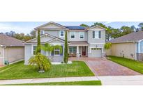 Charming two-story home with a well-manicured lawn and inviting brick-paved driveway at 3252 Jackson Bluff Way, Clermont, FL 34711