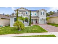 Charming two-story home with a well-manicured lawn and inviting brick-paved driveway at 3252 Jackson Bluff Way, Clermont, FL 34711