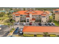 Stunning condo building features a bright orange tile roof and well-maintained landscaping at 445 Bouchelle Dr # 104, New Smyrna Beach, FL 32169