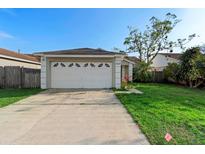 Charming single Gathering home with a two-car garage and well-manicured lawn on a sunny day at 4618 Prairie Point, Kissimmee, FL 34746