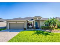 Charming one-story home featuring a well-manicured lawn, a two-car garage, and a blue front door at 4862 Grand Vista Ln, St Cloud, FL 34771