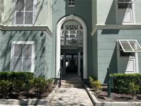 Elegant building entrance features an arched entryway, white trim, and manicured landscaping at 489 Water St # 489, Celebration, FL 34747