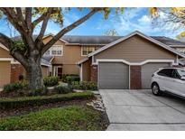 Exterior view of a brown two-story townhome with an attached garage and landscaped front yard at 638 Maple Oak Cir # 112, Altamonte Springs, FL 32701