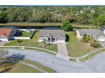 Stunning aerial view of a charming home with a screened-in pool and a serene waterfront backyard at 8706 Irmastone Way, Orlando, FL 32817