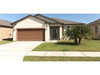 Charming single-story home with a well-maintained lawn and a two-car garage at 8878 Conway Rd, Polk City, FL 33868