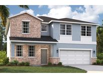 Charming two-story home with stone accents, blue siding and an attached two-car garage at 9560 Starling Loop, Leesburg, FL 34788