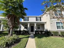 Charming two-story home with manicured lawn and welcoming front porch columns and black shutters at 10079 Memoir Ave, Winter Garden, FL 34787