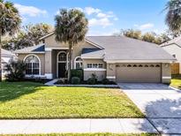 Charming single Gathering home featuring a well-manicured lawn and attached two car garage at 1367 Saddleridge Dr, Orlando, FL 32835