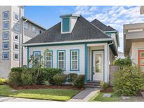 Charming home with a gray roof, blue trim, and well-maintained landscaping and a paver walkway at 14165 Moniz Ave, Orlando, FL 32827