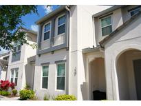 Charming two-story home with white exterior, gray trim, manicured landscaping, and a welcoming front entrance at 159 Captiva Dr, Davenport, FL 33896
