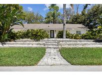 Charming single-story home featuring a beautifully landscaped front yard with lush greenery and a welcoming entrance at 2440 Westwood Dr, Longwood, FL 32779