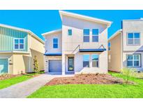 Beautiful two-story home featuring a modern design, well-kept lawn, and attached garage with stone accents at 2661 Petition Ln, Kissimmee, FL 34746