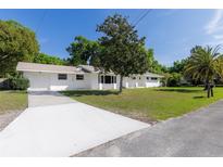 Charming single-story home featuring a manicured lawn and a freshly paved driveway under a sunny sky at 339 Cumberland Rd, Deland, FL 32724