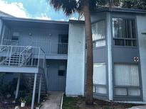Two-story condominium building with exterior stairs and a mature palm tree at 4358 Aqua Vista Dr # G, Orlando, FL 32839