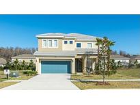 Two-story home featuring a blue garage door, a neutral-colored facade, and well-maintained landscaping at 4507 Monado Dr, Kissimmee, FL 34746