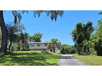 Two-story home with a large yard and mature trees providing ample shade on a sunny day at 500 Forest Lake Dr, Altamonte Springs, FL 32714