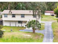 Charming two-story home featuring a well-manicured lawn, mature trees and a long driveway at 500 Forest Lake Dr, Altamonte Springs, FL 32714