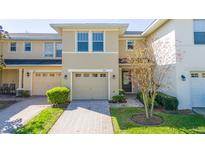 Inviting townhome with a well-manicured lawn and a single-car garage with a neutral colored door at 5412 Caramella Dr, Orlando, FL 32829