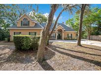 Charming single-Gathering home featuring a manicured lawn, mature trees, and a welcoming facade at 5850 Sheryl Anita St, Oviedo, FL 32765