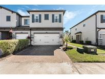 Charming two-story townhome with a two-car garage and a brick-paved driveway at 11980 Sands Cv, Orlando, FL 32828