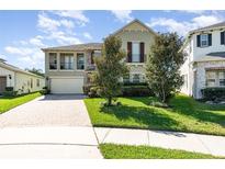 Charming two-story home featuring a stone accent, balcony, and manicured lawn at 14486 Sunbridge Cir, Winter Garden, FL 34787