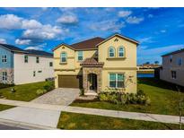 Beautiful two story home featuring manicured lawn, stone details, two-car garage and a covered entryway at 2145 Fleming Mist Pl, Kissimmee, FL 34747