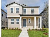 Charming two-story home featuring a welcoming front porch, blue door and neutral siding at 2354 Broadbrook Dr, St Cloud, FL 34771