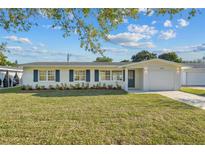 Charming single-story home featuring a well-manicured lawn and tasteful landscaping, creating a welcoming curb appeal at 2418 Whitehall Cir, Winter Park, FL 32792