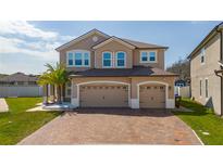 Charming two-story home featuring a three-car garage and a brick paver driveway at 2424 Varenna Loop, Kissimmee, FL 34741